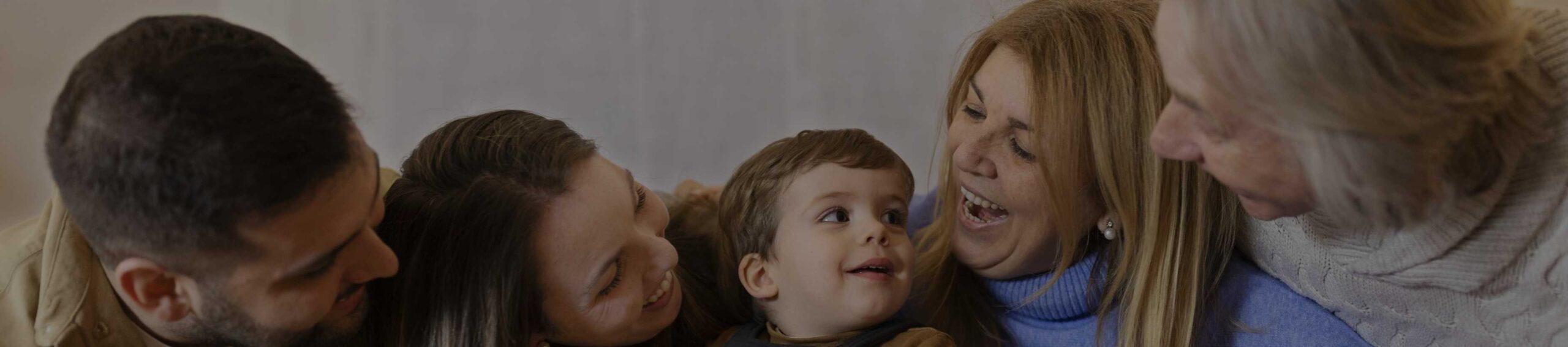 criança sentada no meio dos pais e avós