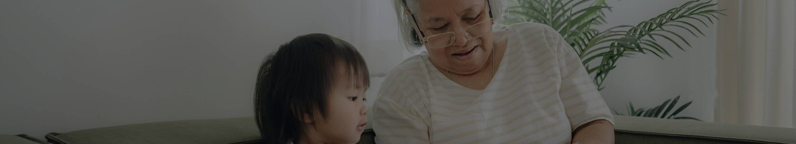 neta e avó sentadas em um sofá dentro de casa