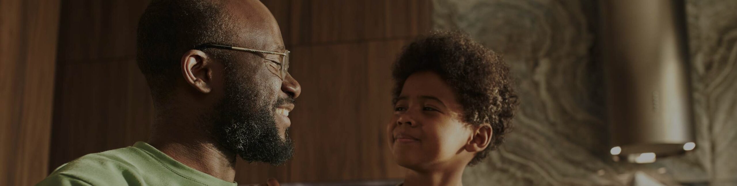 pai e filho dentro de casa olhando um para o outro em um brilho quente de verão