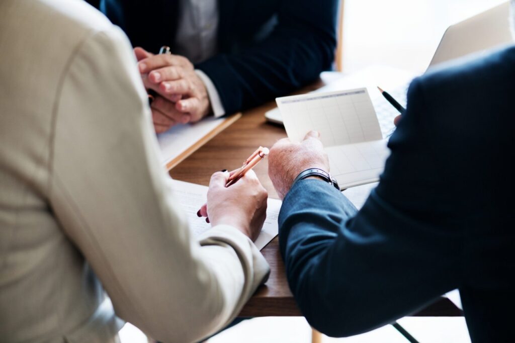 três advogados no Brasil sentados à mesa conversando sobre direitos de herança