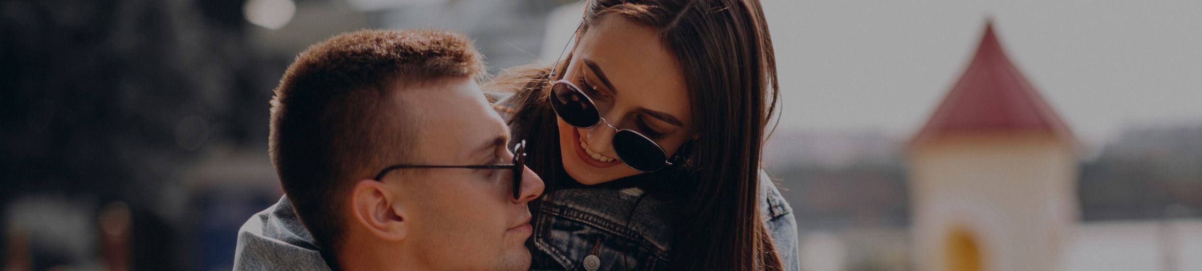 um homem e uma mulher usando óculos de sol se abraçando