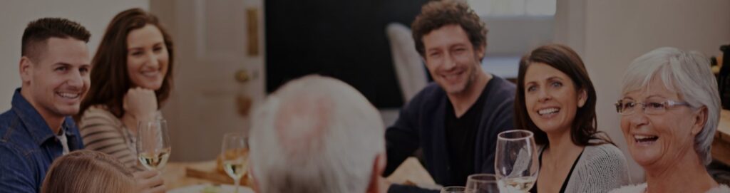 Irmãos e pais à mesa de jantar, com o pai fazendo um brinde.