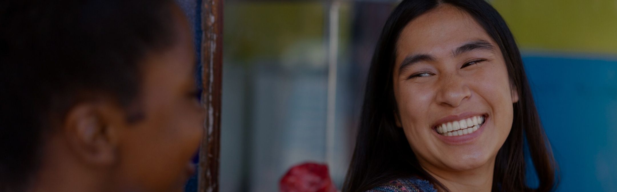 mulher brasileira de ascendência indígena rindo com sua amiga