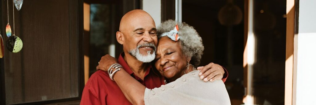 um casal de idosos negros se abraçando