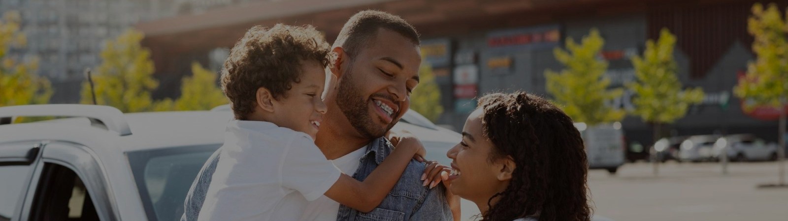 um pai segurando seu filho e olhando para sua esposa