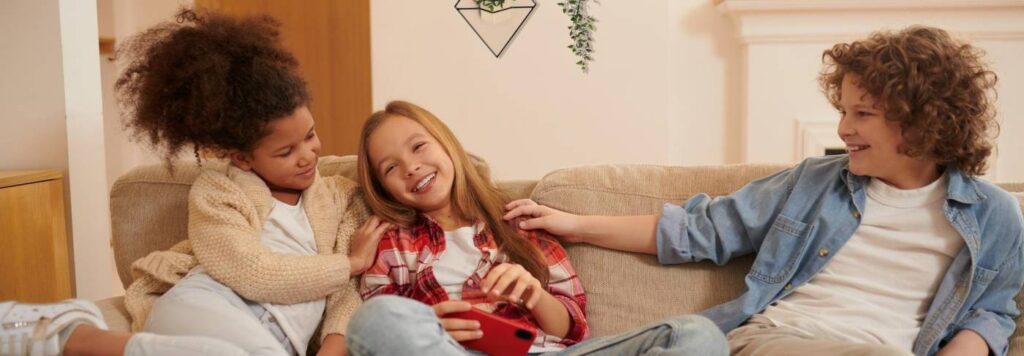 Primos jovens no sofá brincando um com o outro.