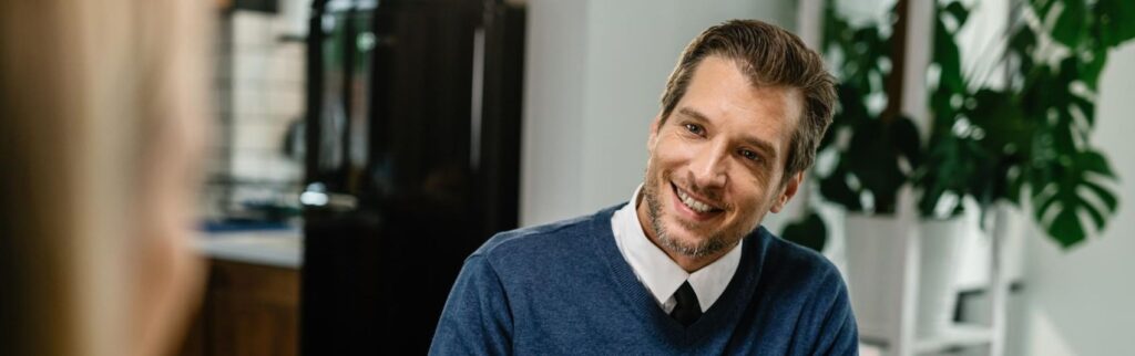 Um advogado para inventário sorrindo para seu cliente no escritório.