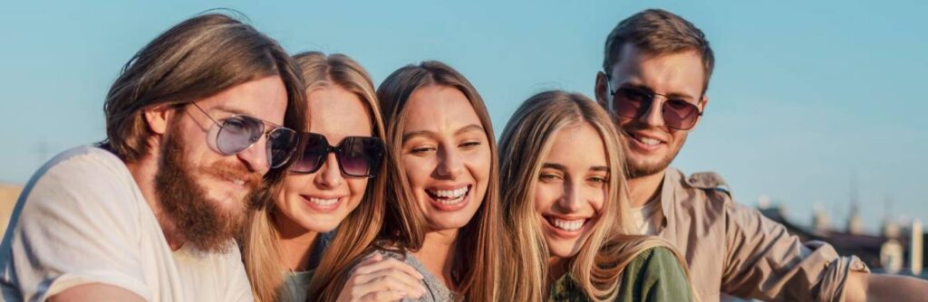 primos adultos tirando uma foto ao ar livre, aproveitando o sol.