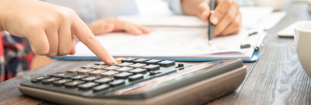 Um advogado sentado com seu cliente calculando o custo do processo judicial.