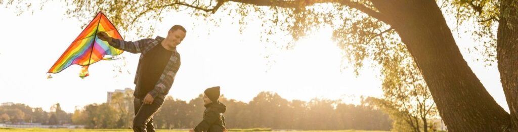 Homem empinando pipa com o filho de sua companheira.