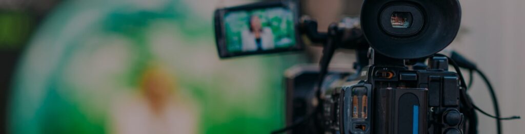Close-up de uma câmera de vídeo filmando alguém.