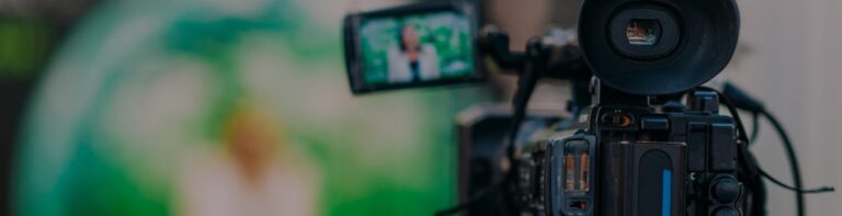 Close-up de uma câmera de vídeo filmando alguém.