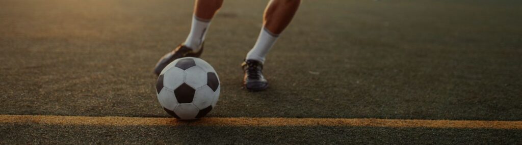 Foto ampliada de Neymar Jr. driblando uma bola de futebol.