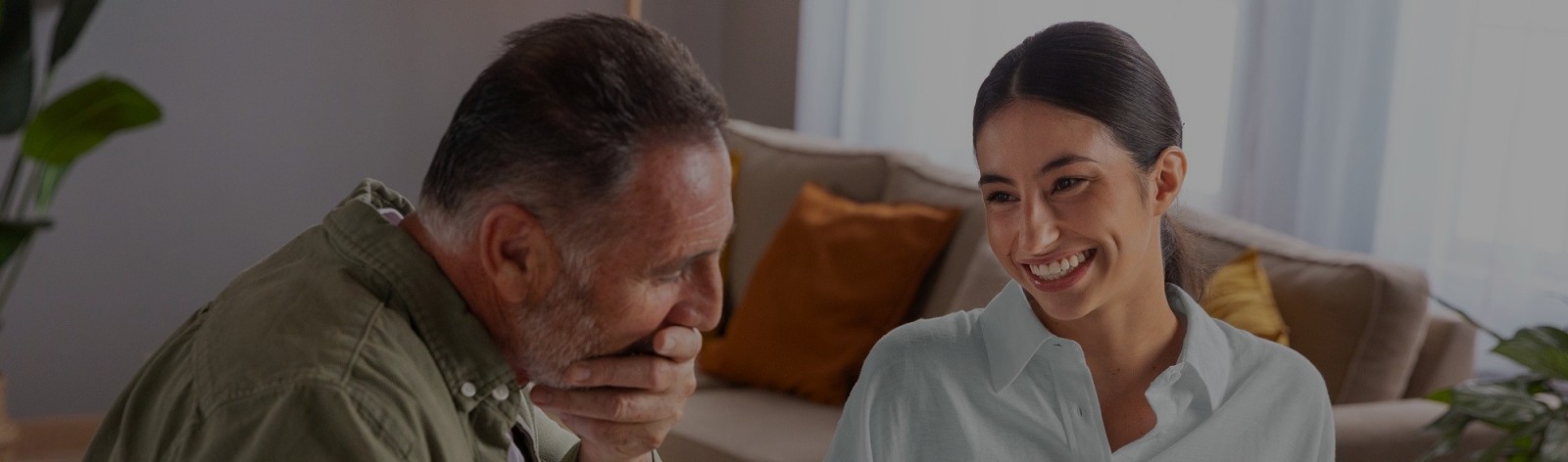 Pai e filha em casa folheando um álbum de fotos da família.