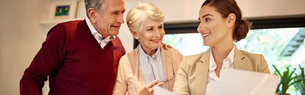 Um casal de idosos com um advogado especializado em direito sucessório analisando documentos.