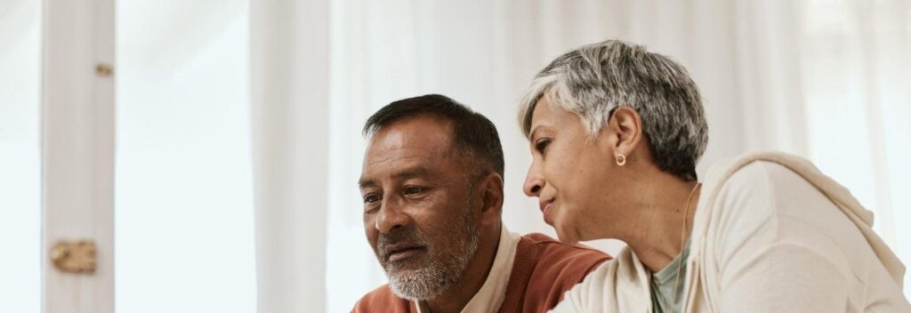um casal de idosos olhando para um computador